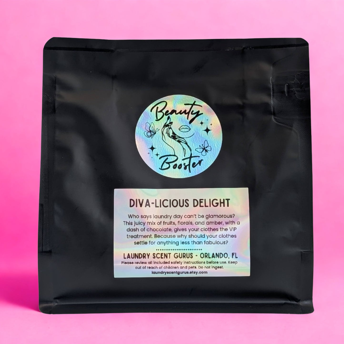 Black bag with 'Beauty Booster' label on a pink background