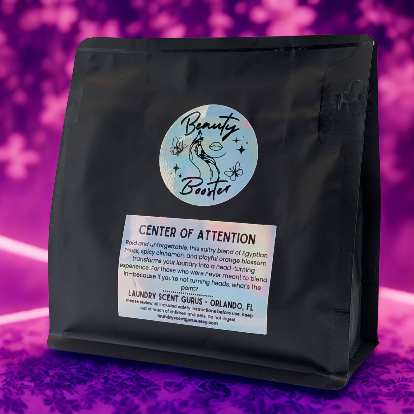 Black bag with 'Beauty Booster' label on a purple background