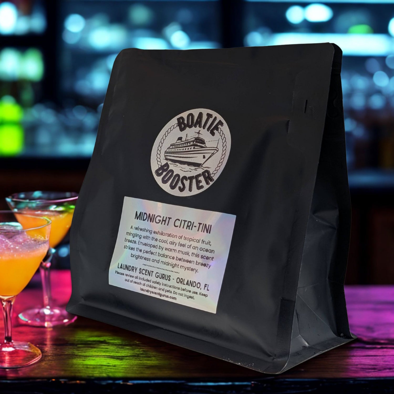 Black bag with a label on a bar counter with cocktails in the background