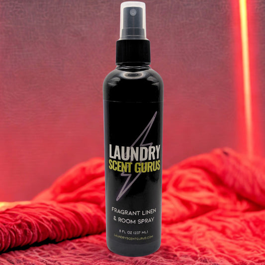Black spray bottle labeled 'Laundry Scent Gurus' on a red textured background