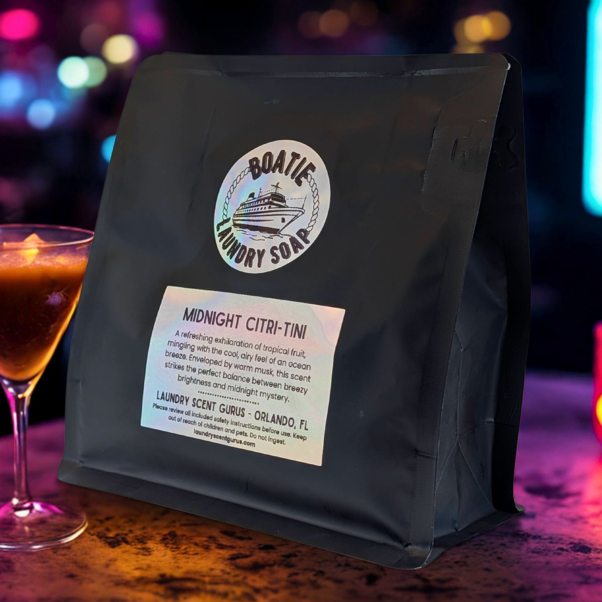 Black bag of BOATIE LAUNDRY SOAP with a label on a colorful, blurred background