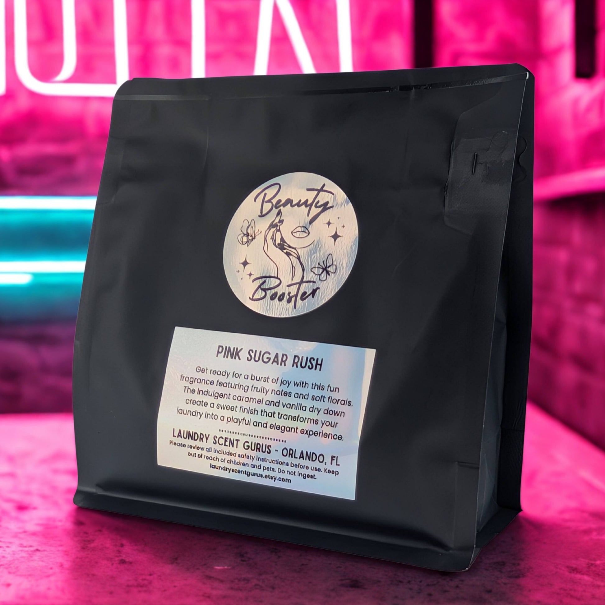 Black bag of 'Pink Sugar Rush' laundry scent with a colorful background