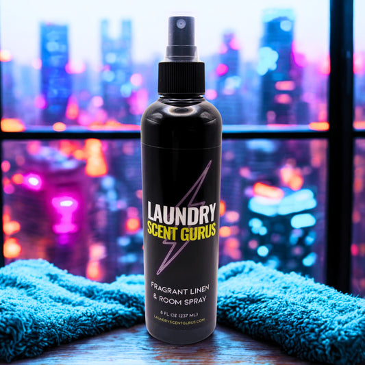 Laundry Scent Gurus spray bottle with blue towels against a cityscape background