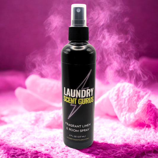 Black spray bottle labeled 'Laundry Scent Gurus' on a pink textured background