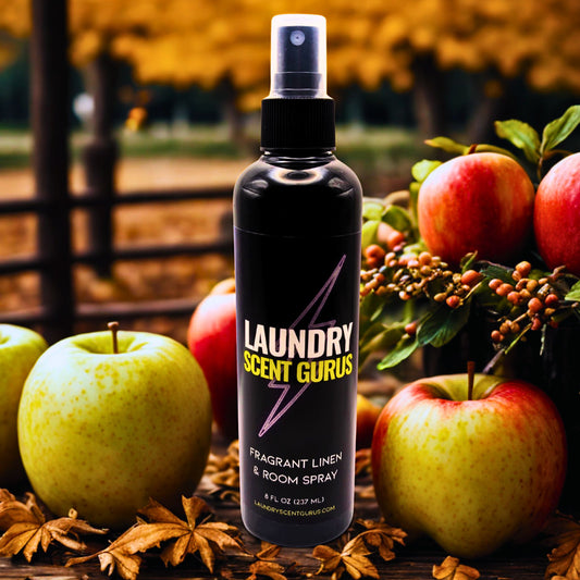 bottle infront of apples with fall leaves and fence